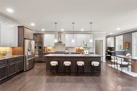 a kitchen with stainless steel appliances granite countertop a refrigerator a sink and a stove