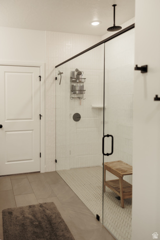 629 Spring Lily Drive St. George, UT 84790 - Photo 14 of 50 Glass-enclosed shower featuring white subway tile walls and a contrasting herringbone pattern tile floor