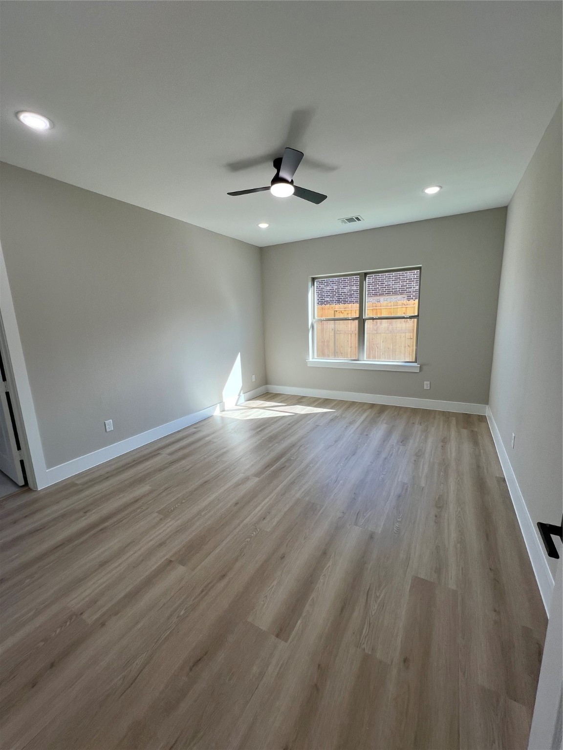 2603 Piemonte Ct Ave Spring Spring, TX 77388 - Photo 11 of 30 an empty room with wooden floor chandelier fan and windows