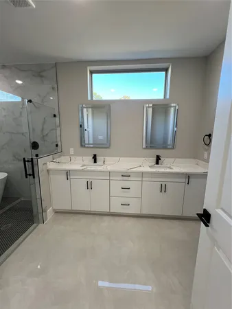 a bathroom with a double vanity sink a mirror and a bathtub
