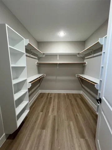 a view of walk in closet with empty racks