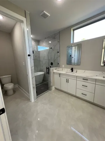 a bathroom with a sink a toilet and shower