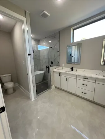 a bathroom with a sink a toilet and shower