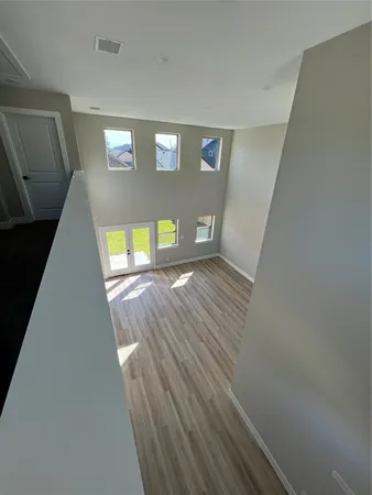 a view of empty room with wooden floor