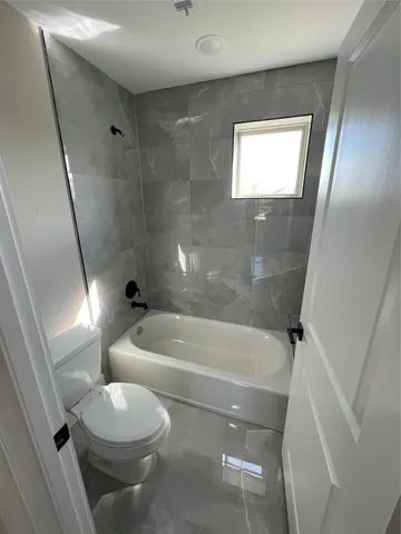 a bathroom with a bathtub and toilet