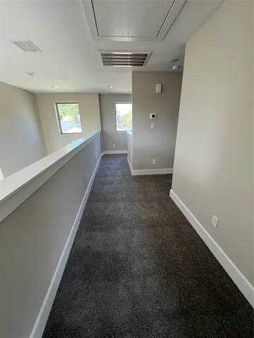 a view of hallway with window and stairs