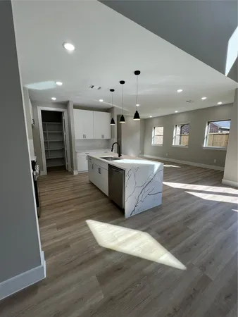 a living room with a bed furniture and kitchen view