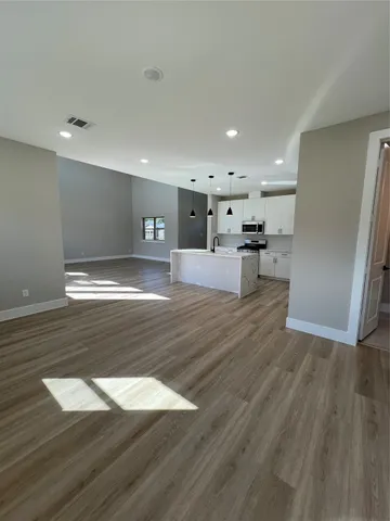 a view of a kitchen with a sink and wooden floor