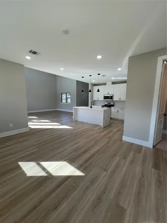a view of a kitchen with a sink and wooden floor