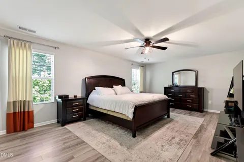 a bedroom with a bed dresser and a window