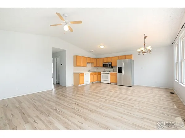 a view of a livingroom with a ceiling fan wooden floor and a ceiling fan