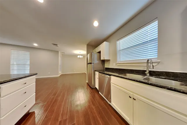 a kitchen with granite countertop a sink and wooden floor