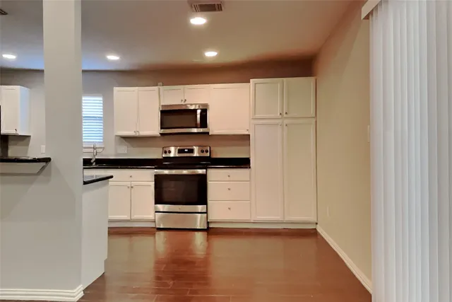 a kitchen with a refrigerator and a stove top oven