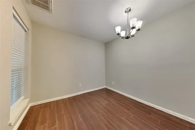 a view of a room with wooden floor and a window