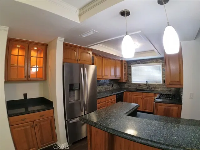 a kitchen with stainless steel appliances granite countertop a sink refrigerator and microwave