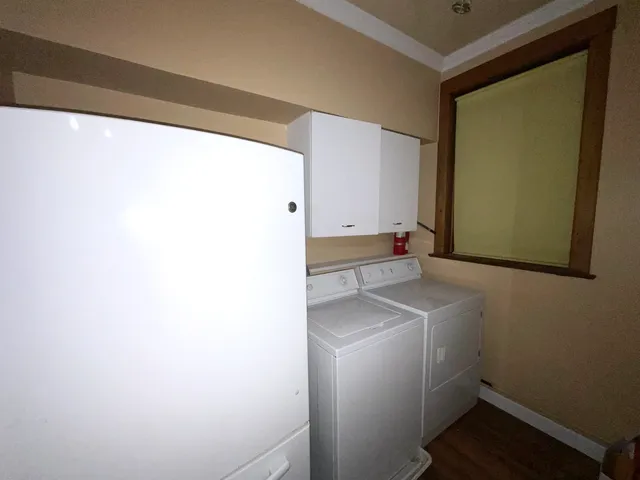 an empty room with wooden floor and fan