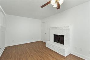 9524 Military Parkway, Unit 5002 Dallas, TX 75227 - Photo 2 of 11 a living room with a fireplace and wooden floor