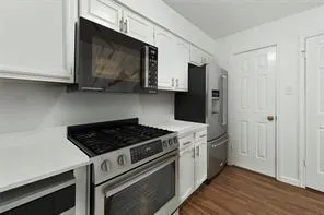 a kitchen with stainless steel appliances granite countertop a stove a microwave and a refrigerator
