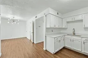 a kitchen with a sink cabinets and wooden floor