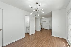 9524 Military Parkway, Unit 5002 Dallas, TX 75227 - Photo 6 of 11 an empty room with wooden floor and a hallway