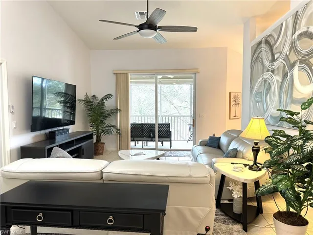 a living room with a table chairs and a flat screen tv