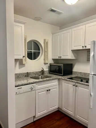 a kitchen with granite countertop a sink and cabinets