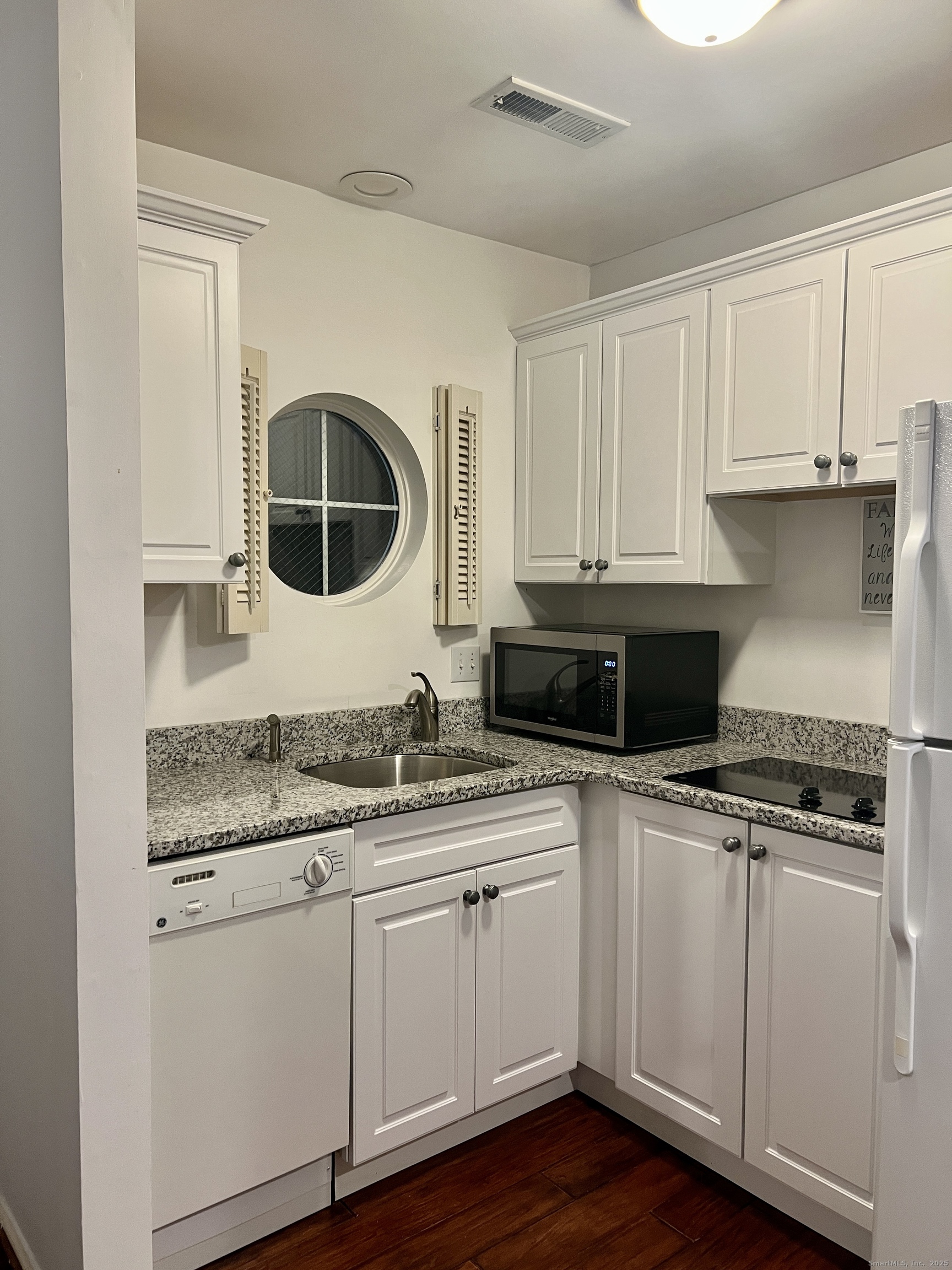 a kitchen with granite countertop a sink and cabinets