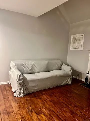 a living room with a bed and a wooden floor