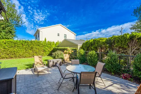a backyard of a house with table and chairs