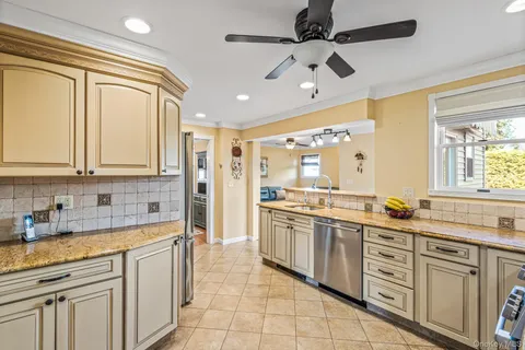 a large kitchen with stainless steel appliances a sink and cabinets