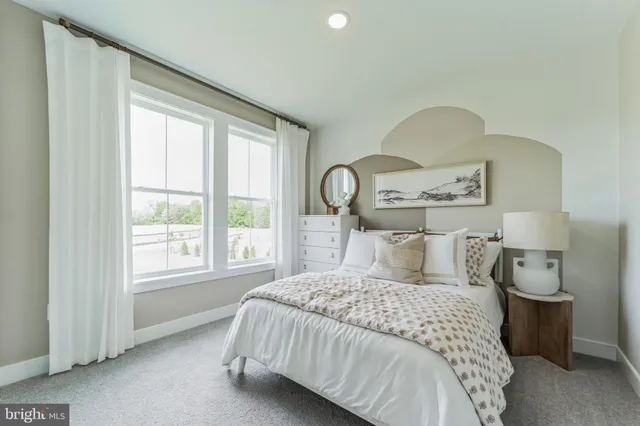 a bedroom with a bed and a large window