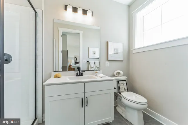a bathroom with a toilet sink vanity and mirror