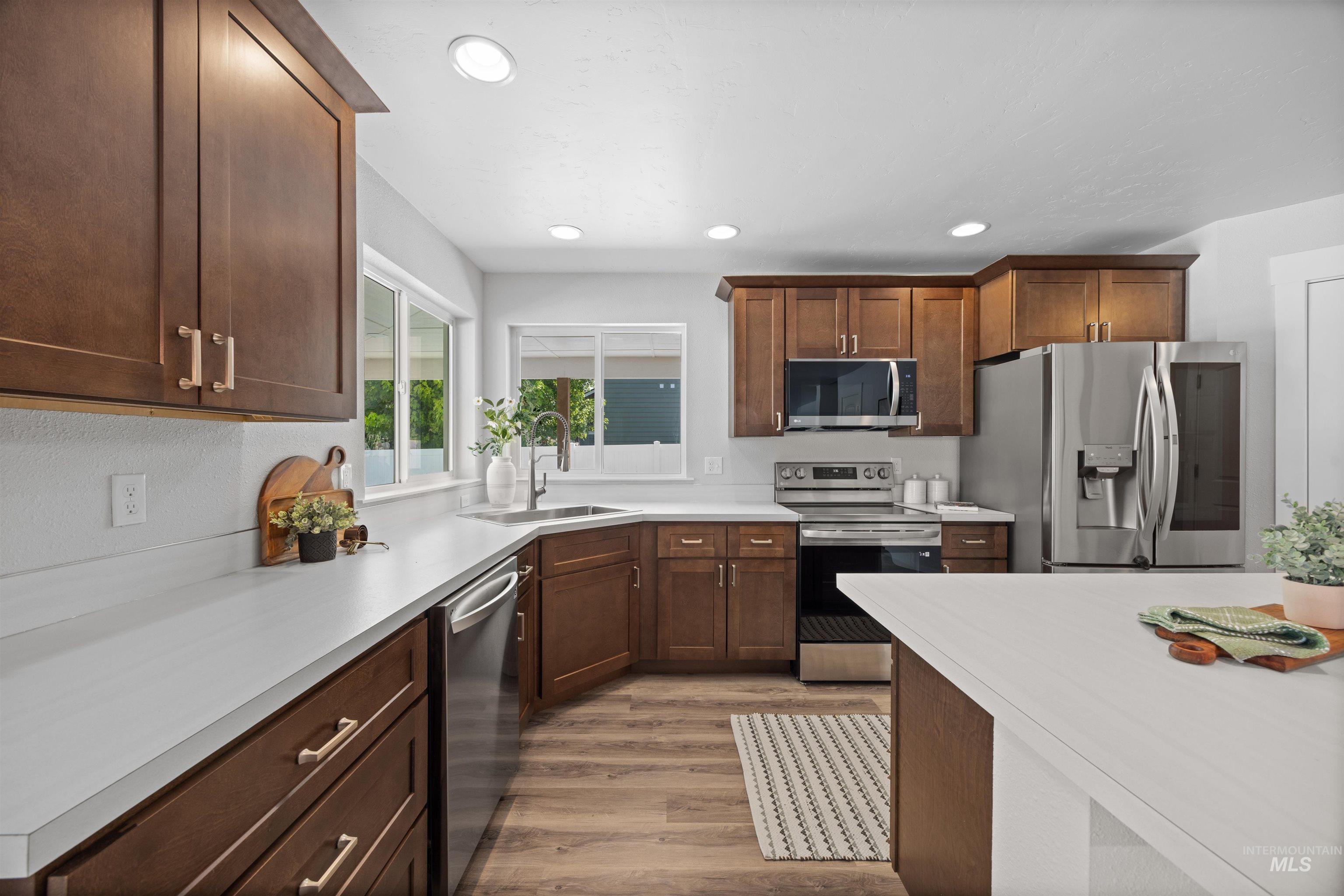 300 South Rocker Avenue Kuna, ID 83634 - Photo 16 of 49 Modern kitchen featuring dark wood cabinetry, stainless steel appliances, and light-toned countertops