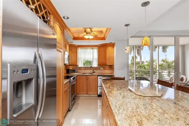 a kitchen with stainless steel appliances granite countertop a sink a stove and a refrigerator