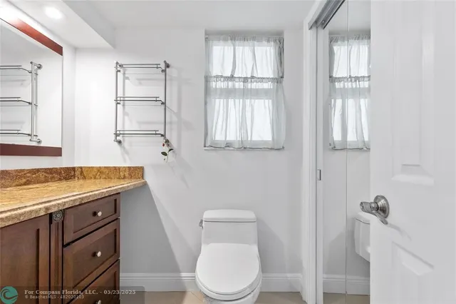 a bathroom with a granite countertop toilet sink and mirror