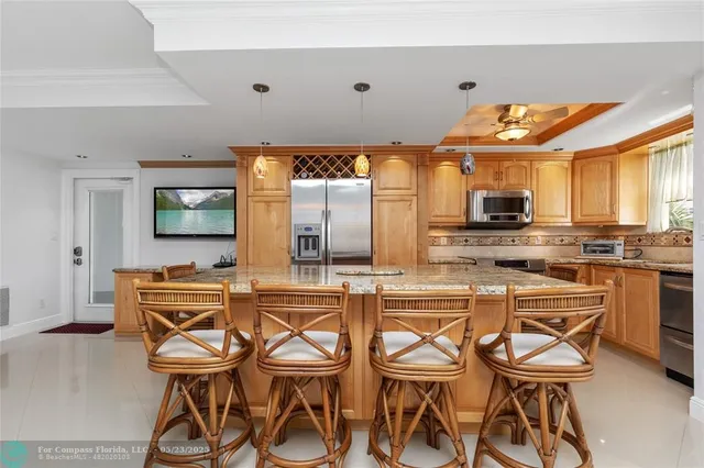 a dining hall with stainless steel appliances kitchen island granite countertop a stove and cabinets