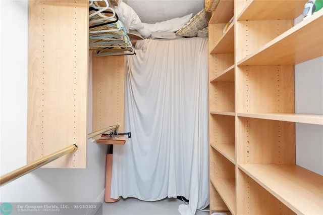 a view of walk in closet with clothes and shoes