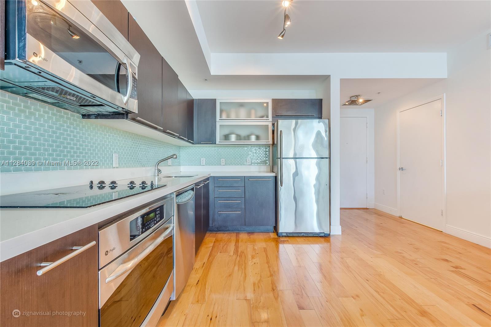 90 Southwest 3rd Street, Unit 3012 Miami, FL 33130 - Photo 3 of 16 a kitchen with stainless steel appliances granite countertop a refrigerator a stove and a wooden floors