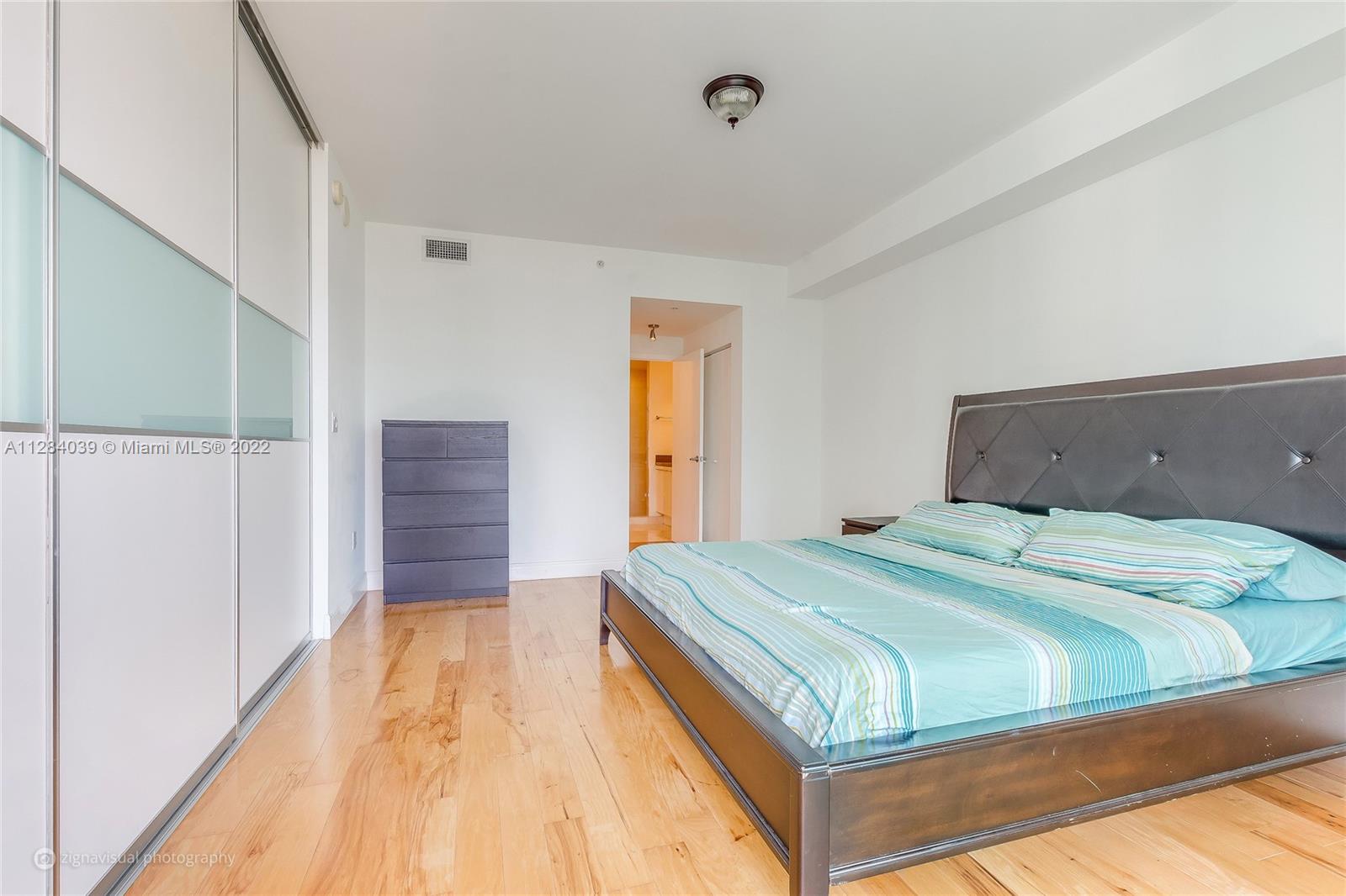 90 Southwest 3rd Street, Unit 3012 Miami, FL 33130 - Photo 8 of 16 a bedroom with a bed and wooden floor