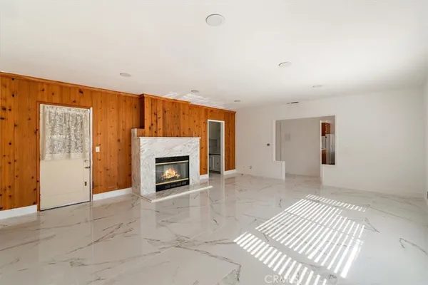 an empty room with windows and fireplace