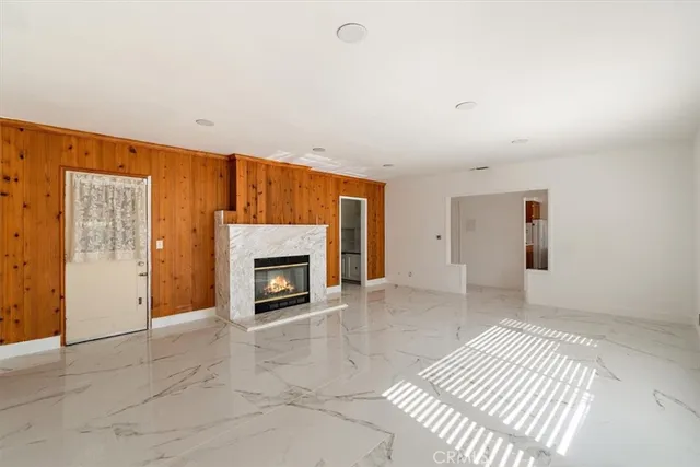 an empty room with windows and fireplace
