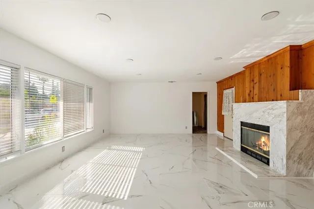 a view of an empty room with a fireplace and a window