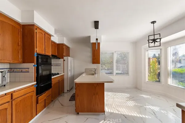 a kitchen with stainless steel appliances granite countertop a stove a sink and a refrigerator