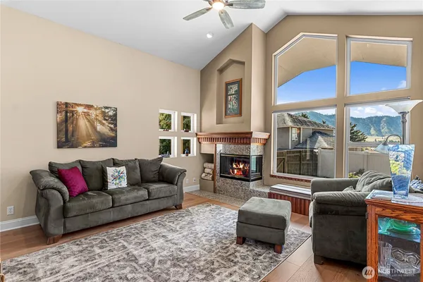 a living room with furniture a fireplace and a floor to ceiling window