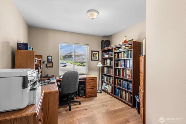 a view of a workspace with furniture and a bookshelf