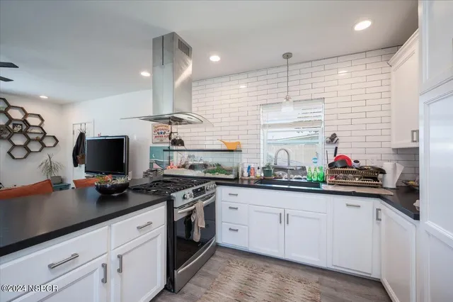 a kitchen with stainless steel appliances granite countertop a sink and a stove