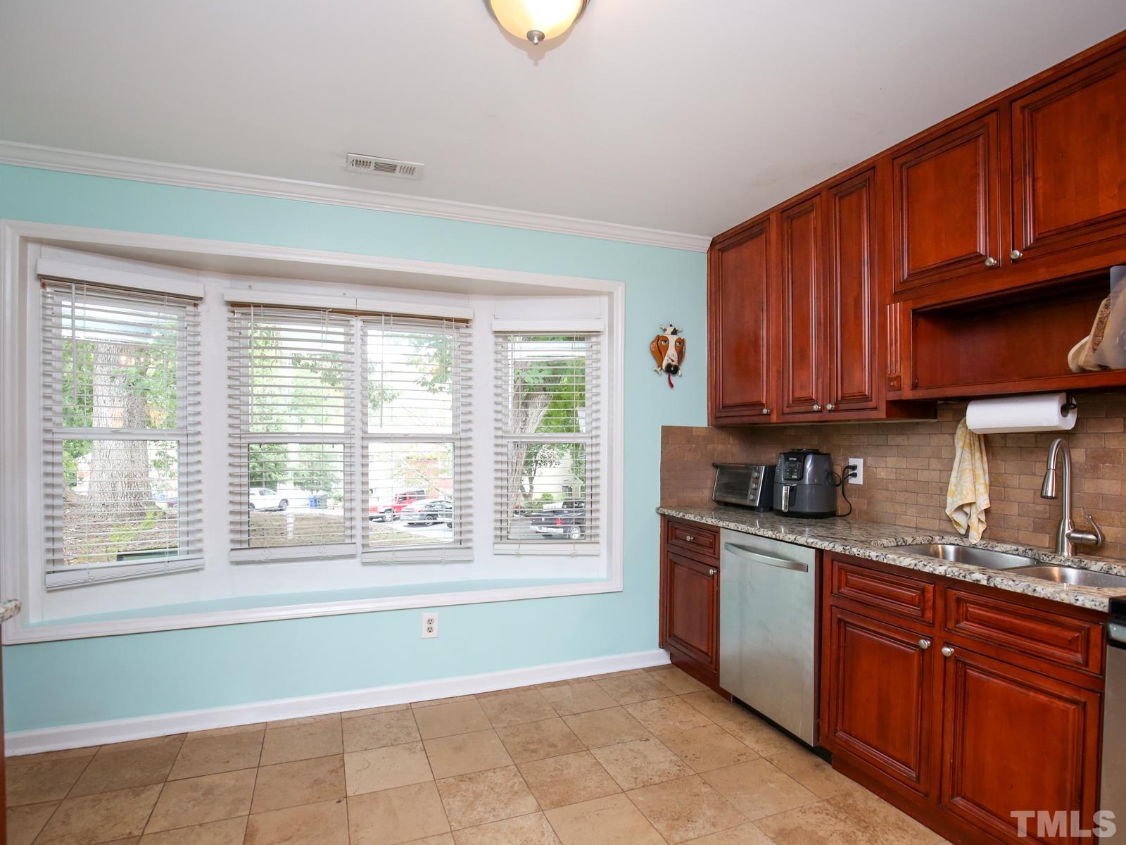 5423 Pine Top Circle Raleigh, NC 27612 - Photo 7 of 30 a kitchen with stainless steel appliances granite countertop a stove sink and cabinets