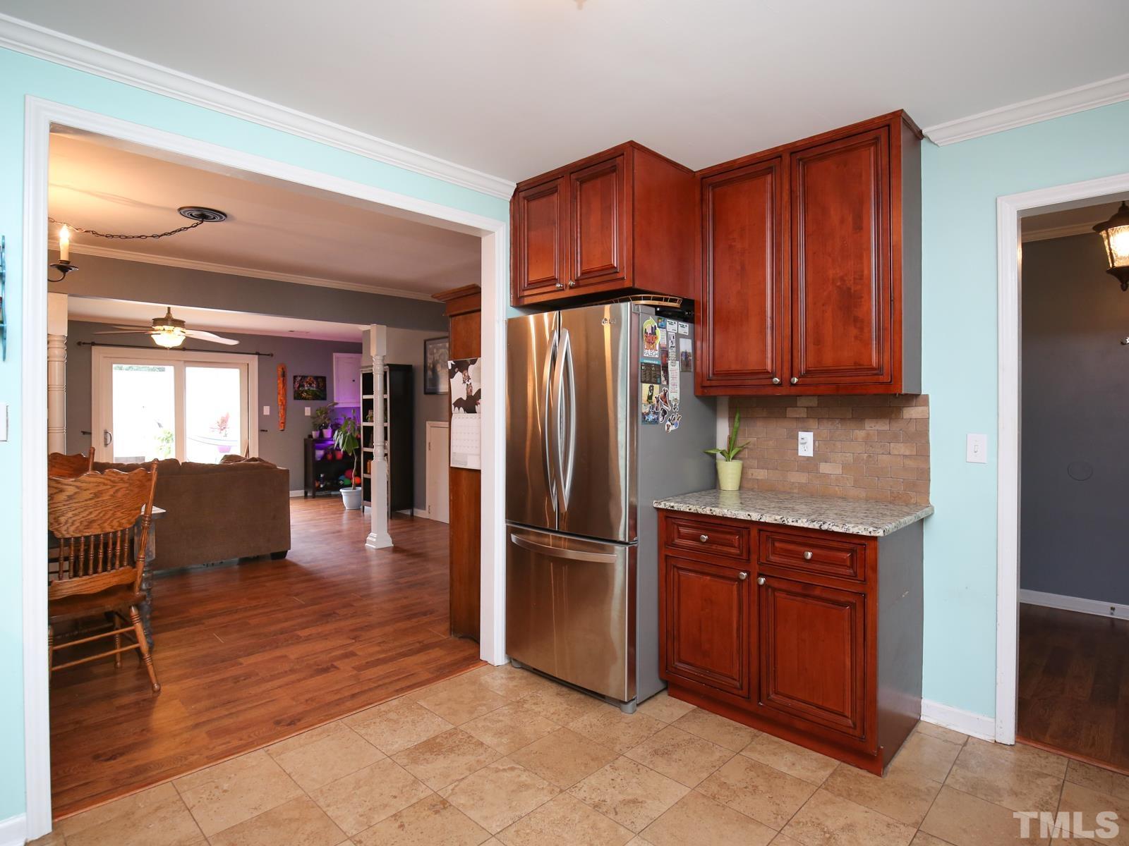 5423 Pine Top Circle Raleigh, NC 27612 - Photo 9 of 30 a kitchen with stainless steel appliances granite countertop a refrigerator and wooden cabinets