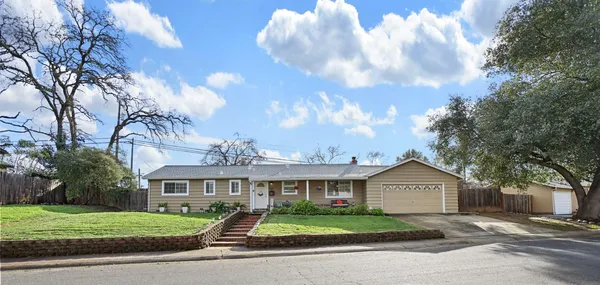 a view of a big house with a big yard and large trees