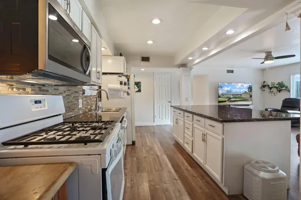 a kitchen with stove a sink and refrigerator